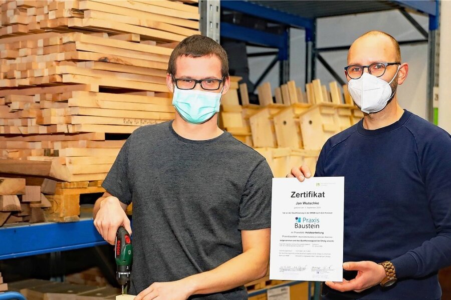 Jan Wutschke (links) freut sich über sein Zertifikat im Praxisbaustein Holz, das ihm sein Ausbilder Christian Röhnert (rechts) übergab. 