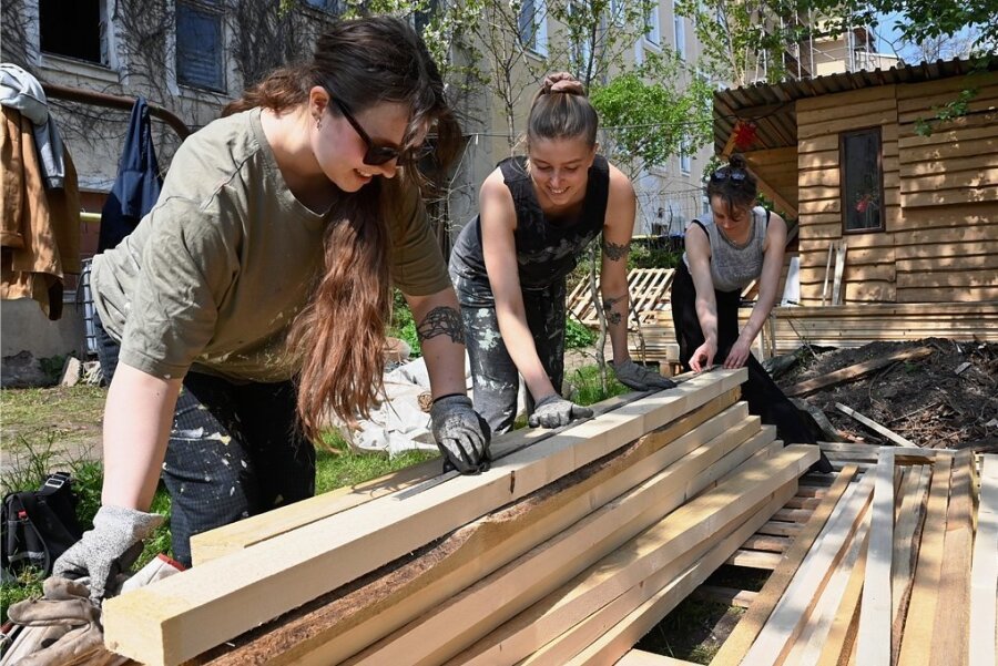 Mit Hilfe aus der Sauna-Hauptstadt: Hier können die Chemnitzer in Zukunft schwitzen - Roosa Kontiokari und Aurora Millasnoore aus Finnland sowie Ulrike Brantl vom Klub Solitaer (von links) sortieren als einen ersten Arbeitsschritt das Bau-material für die Sauna, die am Donnerstag nächster Woche im Gemeinschaftsgarten Zietenaugust eingeweiht werden soll. 