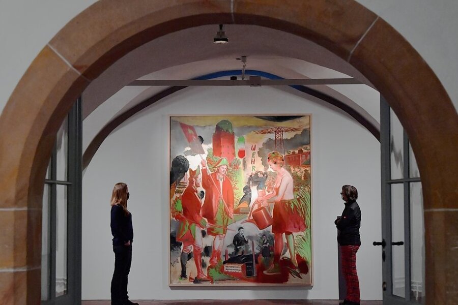 Besucherinnen betrachten das Bild "Wehr" des Malers Neo Rauch in der Sonderausstellung "Das Wehr" in der Gewölbehalle im Nordflügel der Hei-decksburg. 