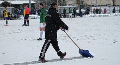 Mit oder ohne Schnee: RFC will spielen - Auf verschneitem Kunstrasen: RFC-Torwarttrainer Lutz Rodewald macht die Strafraumlinie frei. 