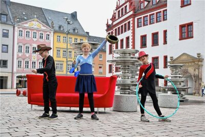 Mit Zylinder, Sombrero und Melone: Chemnitzer Hutfestival beginnt am Freitag - Jeason, Lene (Mitte) und Leyla vom Kinder- und Jugendzirkus Birikino gaben am Dienstag auf dem Markt einen Vorgeschmack ihres Könnens, das sie zum Hutfestival zeigen werden. Foto: 