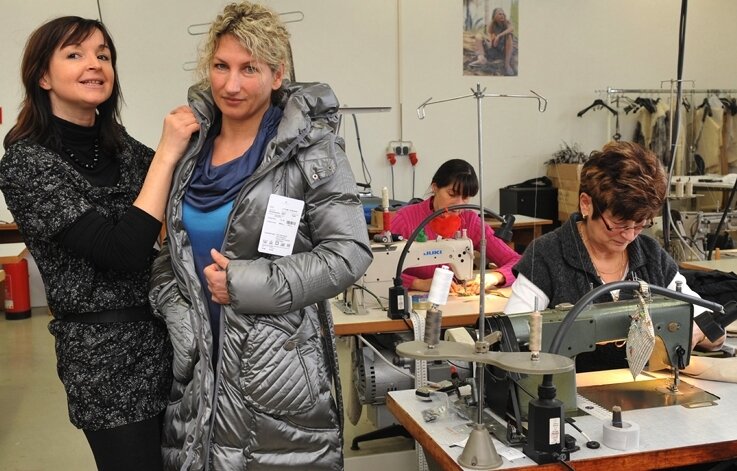 <p class="artikelinhalt">Modee-Geschäftsführerin Claudia Friedrich (links) und Musternäherin Kerstin Friedrich präsentieren einen Daunenmantel, der in Schkeuditz zu sehen sein wird. </p>
