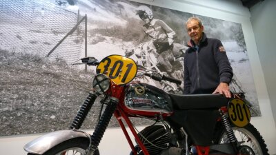 Motorrad-Enthusiasten haben mehr Zeit für Liebe zum Detail - Im Museum hängen erste große Banner. Hier steht Eberhard Weber, der Vorsitzende des Fördervereins, samt originaler Zündapp-Maschine vor einem Bild, das ihn bei den Six Days 1974 in Italien zeigt. 