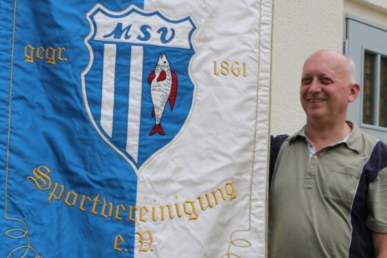 Vereinsvorsitzender Karl-Heinz Lindner zeigt die neue Vereinsfahne, die der Mühltroffer Sportverein vor fünf Jahren einweihte. 