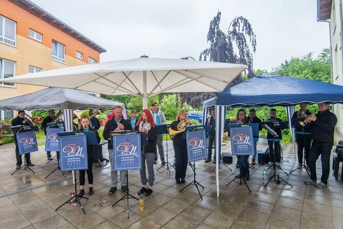 Musiker erfüllen Pflegeheim-Bewohnern großen Wunsch - Die Musiker des Feuerwehrmusikzuges Neukirchen-Adorf vor dem Pflegeheim in Zwönitz.