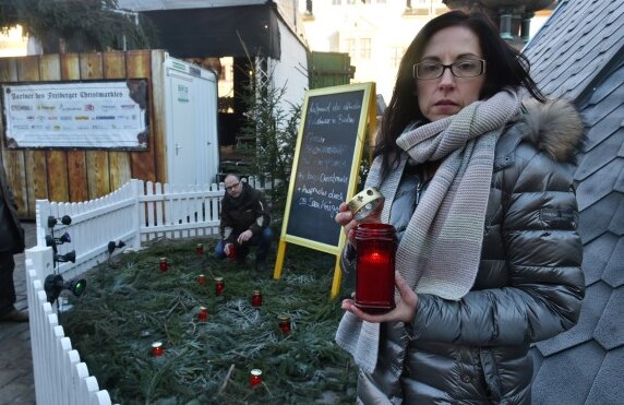 Nach Anschlag in Berlin: Schweigeminute auf dem Freiberger Christmarkt geplant - Anja Fiedler und David Bojack haben am Dienstag auf dem Freiberger Christmarkt zwölf Kerzen zum Gedenken an die Terroropfer von Berlin aufgestellt.