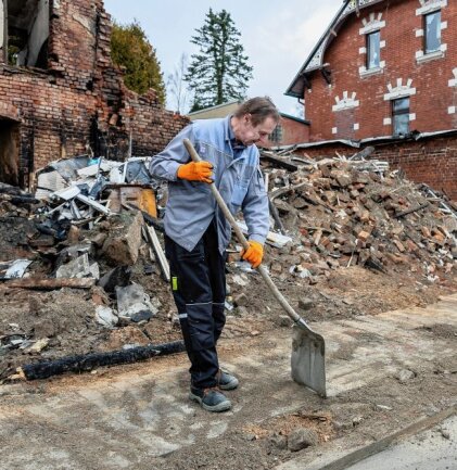 Nach der Explosion in Ellefeld: Was es für Helfer nun zu tun gibt - Bauhofmitarbeiter Jens Müller säubert die Straße von Geröllresten.