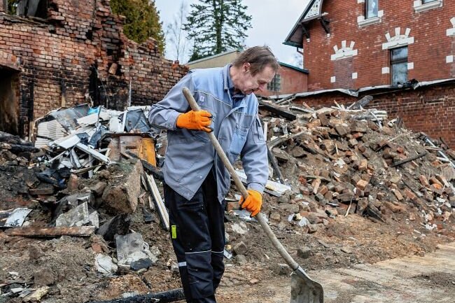 Nach der Explosion in Ellefeld: Was es für Helfer nun zu tun gibt - Bauhofmitarbeiter Jens Müller säubert die Straße von Geröllresten.