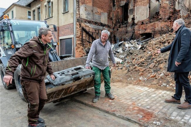 Nach Explosion in Ellefeld: Was es für Helfer nun zu tun gibt - Die Bauhofarbeiter Thomas Dressel und Andreas Kühn (von links) beginnen in Absprache mit Bürgermeister Jörg Kerber (rechts) das Haus notzusichern. Absperrgitter kommen vor den Trümmerhaufen. 