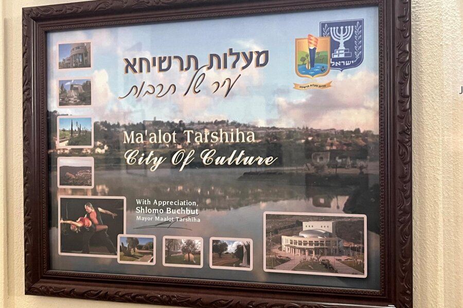 Nach Hamas-Überfall: Reichenbach sorgt sich um Partnerstadt - Ma'alot Tarshiha - Stadt der Kultur steht auf dem Bild, das im Rathaus neben der Partnerschaftsurkunde hängt.