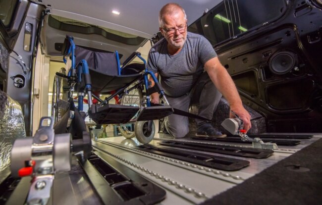 Probestellen: Matthias Schuster testet die Rollstuhlbefestigung in Pauls Auto. Der Fahrzeugboden wurde teilweise durch Aluminium-Planken mit Rasterschienen verstärkt. 