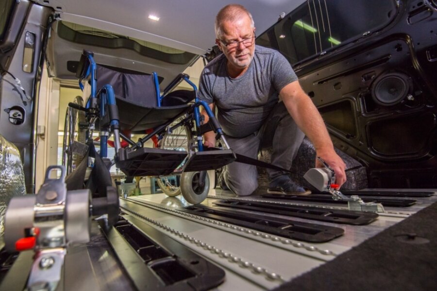 Probestellen: Matthias Schuster testet die Rollstuhlbefestigung in Pauls Auto. Der Fahrzeugboden wurde teilweise durch Aluminium-Planken mit Rasterschienen verstärkt. 