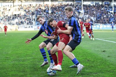 Nach Niederlage des FC Erzgebirge Aue: „So wird es schwer, Spiele zu gewinnen“ - Ein Symbolbild des Tages: Der FC Erzgebirge Aue mit Omar Sijaric am Ball, gestört von kämpfenden Mannheimern.