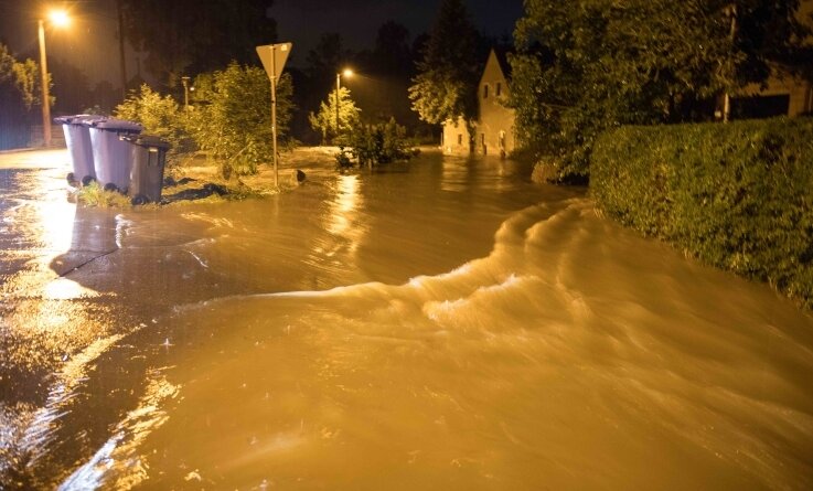 Nach Überflutung in Freiberg: Warum blieb die Warnapp stumm? - Der Münzbach trat über die Ufer und verwandelte die Straße in einen Fluss. Das schlammige Wasser überspülte Grundstücke und drang in Gebäude ein.
