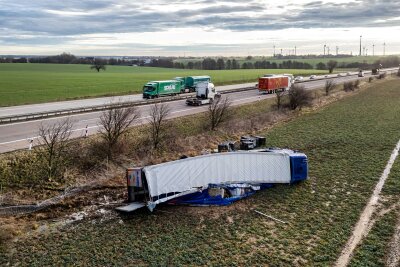 Nach Unfall auf der A14: Umgekippter Lastwagen liegt noch auf dem Feld - Der umgekippte Lastwagen liegt noch immer neben der A14 bei Mutzschen.