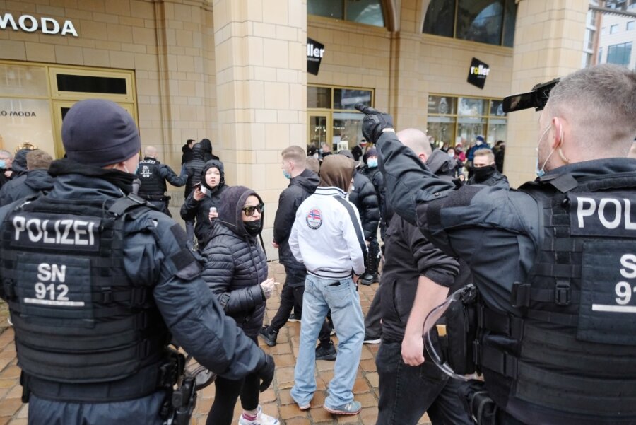 Polizisten gehen gegen Teilnehmer der verbotenen Kundgebung in Chemnitz vor.