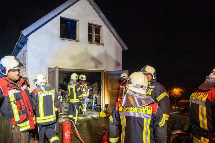 Nächtlicher Feuerwehreinsatz in Grünhain-Beierfeld: Moped brennt in Garage - Die Einsatzkräfte der Feuerwehr bei der Kontrolle der Garage nach dem gelöschten Brand.