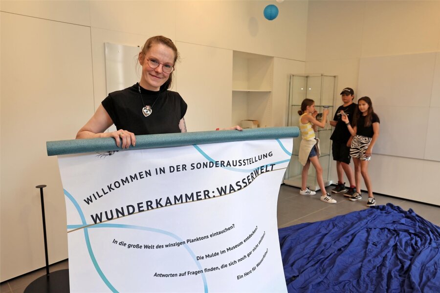 Naturalienkabinett Waldenburg: Familienführungen durch die Sonderausstellung zum Leben im und am Wasser - Museumsmitarbeiterin Sindy Nagy mit einem Plakat zur Sonderausstellung.