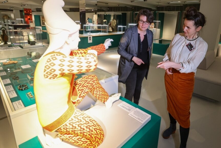 Yvonne Schmuhl und Karina Iwe (von links) haben die neue Ausstellung des Archäologiemuseums zu Schmuck imLaufe der Menschheitsgeschichte kuratiert. Zu den Exponaten gehört die rekonstruierte Kleidung eines Bogenschützen des Aphaiatempels von Ägina (Griechenland).