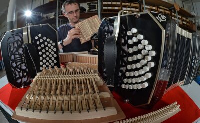 Mit Fingerspitzengefühl montiert Handzuginstrumentenmacher Ralf Skala in der Werkstatt in Klingenthal ein Bandoneon. Die Manufaktur im Vogtland hält die Fertigung in Tradition der legendären AA-Instrumente hoch.