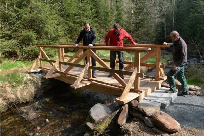 Neue Brücke führt bei Grünbach zur Göltzschtalbastei - Bürgermeister Ralf Kretzschmann und die Bauhof-Mitarbeiter Tilo Möckel und Timo Pöhler (von links) nehmen die neue Fußgängerbrücke über die Weiße Göltzsch in Augenschein. 