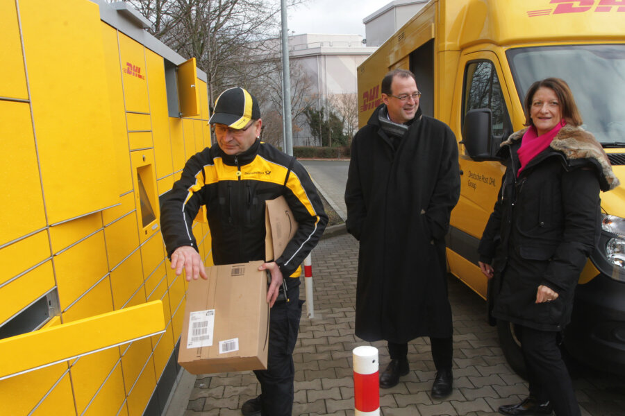 Neue DHL-Packstation geht in Plauen in Betrieb - Zusteller Holger Peterhänsel, Postmitarbeiterin Brigitte Ullrich und Plauens Wirtschaftsförderer Eckhard Sorger an der DHL-Station an der Neundorfer Straße.