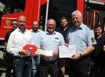 Neue Feuerwehr offiziell übergeben - Pöhls Bürgermeister Erik Jung (links, 1. Reihe) übergab den Schlüssel an Gemeindewehrleiter Helmar Müller (Mitte). 