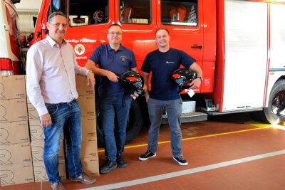 Neue Feuerwehrhelme in Neumark: Warum aus Gelb Schwarz wurde - Bürgermeister Sven Köpp übergibt die Helme an die Wehrleiter Frank Riedel und Christian Flechsig (v.l.).
