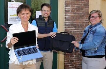 Neue Laptops für die Oberschule - Antje Döbler (rechts), Finanzchefin im Rathaus von Grünhain-Beierfeld, übergibt die neuen Laptops an Schulleiterin Katrin Müller und Lehrer Patrik Sonntag. 