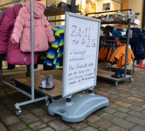 Neue Regeln und alte Sorgen - Seit Montag gilt die 2G-Regel auch im Einzelhandel. Ein Textilgeschäft am Markt in Frankenberg weist mit einem Schild darauf hin. 