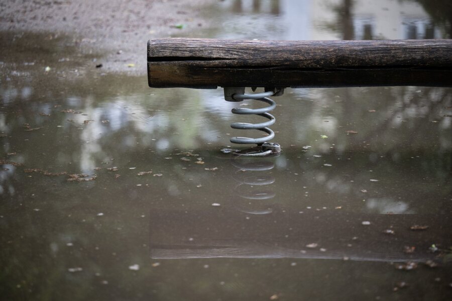 Neue Warnungen vor starkem Gewitter in Sachsen - Eine Wippe auf einem Spielplatz steht im Wasser.