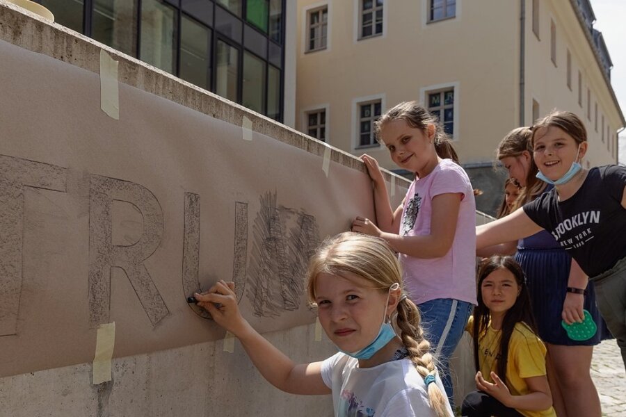 Die graue Mauer vor dem Bildungszentrum "Adam Ries" soll ein farbenfroher Blickfang werden. Schülerinnen der Klasse 4b gestalten ihn innerhalb eines Ganztagesangebotes unter Leitung von Sabine Sachs. 