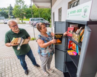 Neuer Bücherschrank auf Nahkauf-Parkplatz in Jahnsdorf - Der Heimatverein freut sich, dass der Bücherschrank auf dem Parkplatz des Nahkaufs gut angenommen wird. Die Vereinsmitglieder Christa Götz und Herbert Pchalek befüllen ihn. 