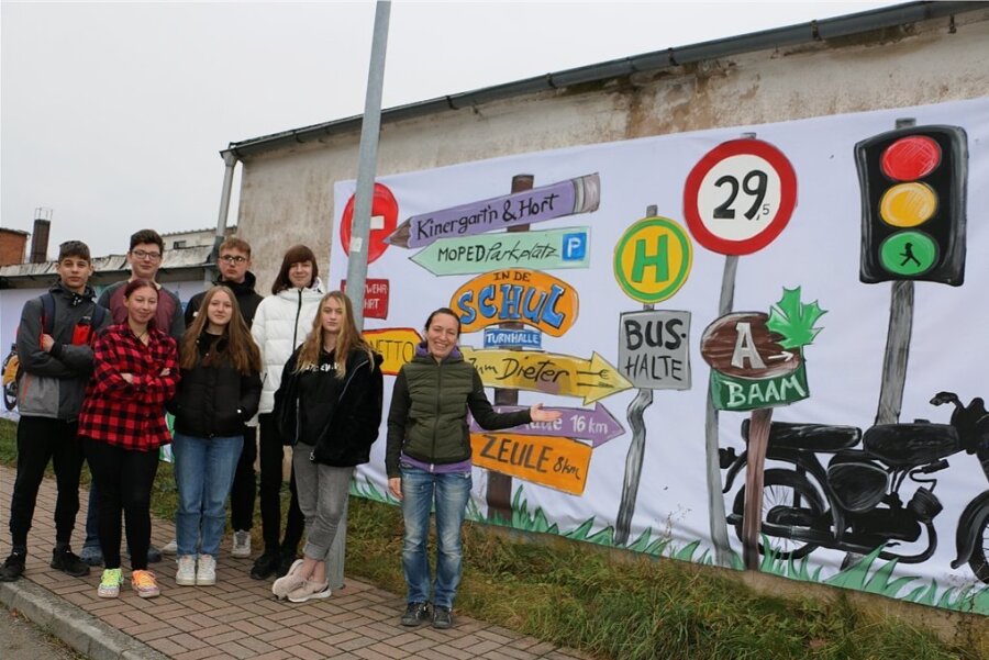 Die Pausaer Zehntklässler und Alexandra Wermig (rechts) vor der gestalteten Wand gegenüber der Pausaer Schule.
