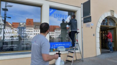 Neues Impfzentrum öffnet diese Woche - Sebastian und Robert Liebscher (von links) von der Firma Druckgemacht gestalteten am Montag das Schaufenster. 