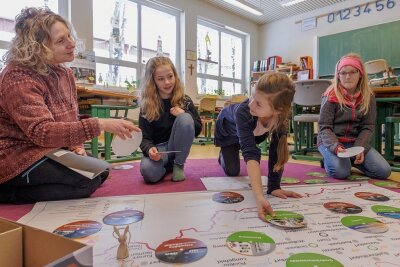 Neues Lernspiel erklärt das Erzgebirge - Lehrerin Ariane Grund (links) von der Montessori-Grundschule in Annaberg-Buchholz hat das neue Lernspiel mit entwickelt. Einem ersten Test haben es die Viertklässlerinnen Julika, Ella und Larissa (von links) von den "Wüstenfüchsen" unterzogen. 