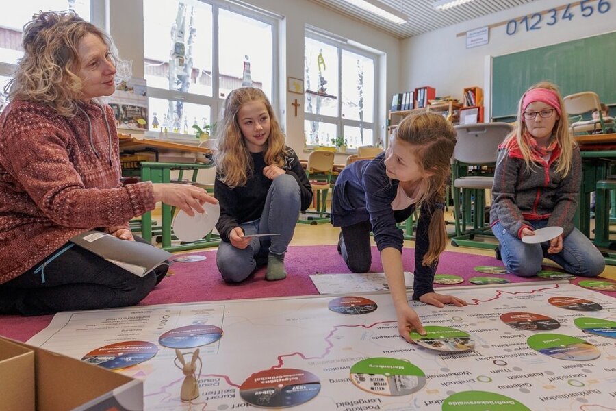Lehrerin Ariane Grund (links) von der Montessori-Grundschule in Annaberg-Buchholz hat das neue Lernspiel mit entwickelt. Einem ersten Test haben es die Viertklässlerinnen Julika, Ella und Larissa (von links) von den "Wüstenfüchsen" unterzogen. 