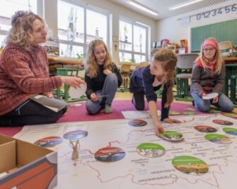 Neues Lernspiel erklärt das Erzgebirge - Lehrerin Ariane Grund (links) von der Montessori-Grundschule in Annaberg hat das neue Lernspiel mit entwickelt. Einem ersten Test haben es Julika, Ella und Larissa (von links) von den "Wüstenfüchsen" unterzogen. 