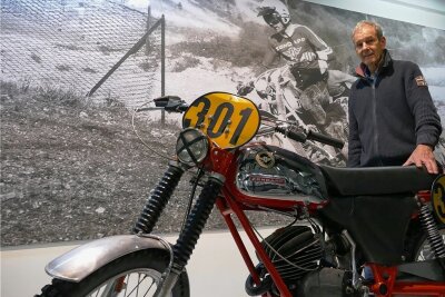 Neues Motorradmuseum in Zschopau - Im Museum hängen erste große Banner. Hier steht Eberhard Weber, der Vorsitzende des Fördervereins, samt originaler Zündapp-Maschine vor einem Bild, das ihn bei den Six Days 1974 in Italien zeigt. 