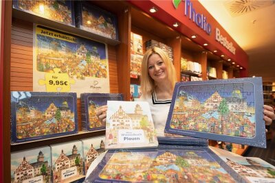 Neues Puzzle vom Plauener Weihnachtsmarkt jetzt im Verkauf - Sophie Gürtler vom Dachverband Stadtmarketing mit dem neuen Puzzle und dem Plauener Wimmelbuch. 