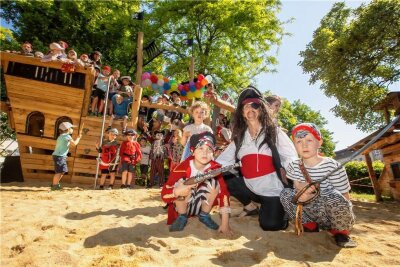 Neues Spielgerät: Kinder entern in Plauen das Piratenschiff Esmeralda - Johann und Heinrich und die anderen Kinder der Kita Pusteblume freuen sich mit Pirat, Erzieherin Silke Berger, über das neue Spielgerät.