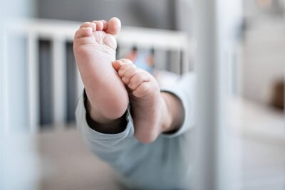 Neujahrs-Baby: Jakob ist der erste kleine Mittelsachse des Jahres - Die Füße eines Babys sind in einem Kinderbett zu sehen.