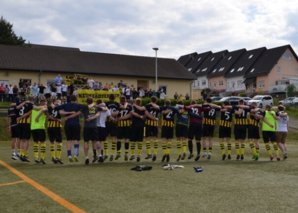 Zusammen mit ihren Fans feiern die Neustädtler Kicker den Klassenerhalt in der Fußball-Erzgebirgsliga. Mit einem 7:0 gegen Crottendorf sammelte die Elf von Trainer Markus Kolbe die letzten notwendigen Zähler. 