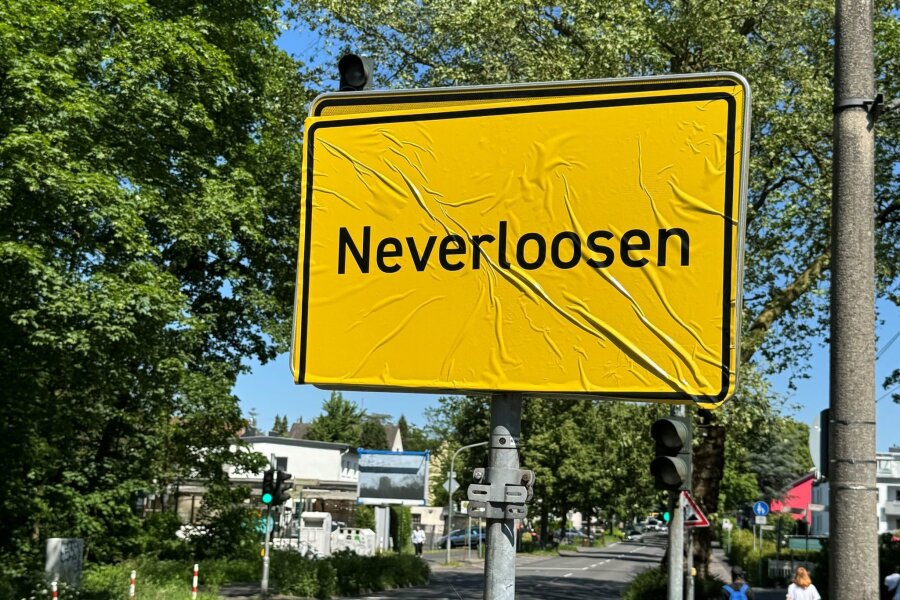 "Neverloosen": Ortschild von Leverkusen überklebt - Das Ortsschild von Leverkusen im Stadtteil Schlebusch ist mit der Aufschrift "Neverloosen" überklebt worden.