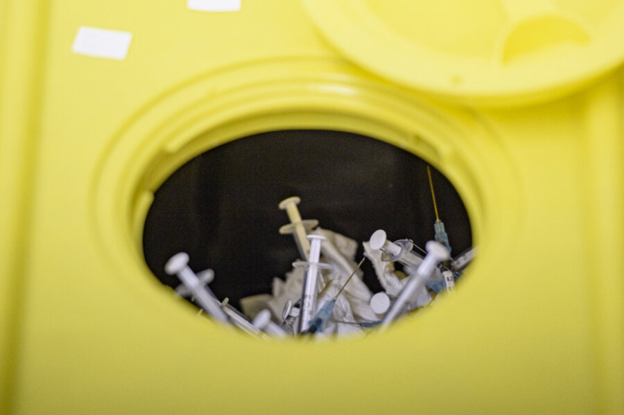 Gebrauchte Impfspritzen liegen in einem Abfallbehälter. Nordrhein-Westfalen baut seine Lagerbestände des kaum noch nachgefragten Corona-Impfstoffs von Astrazeneca ab. 