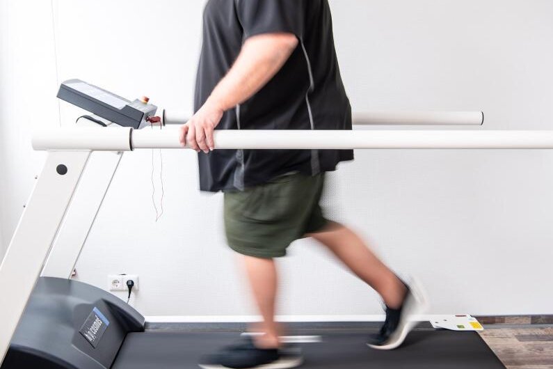            Ein Mann trainiert an einem Laufband um seine Ausdauer nach einer Coronainfektion zu stärken. (Archivbild).