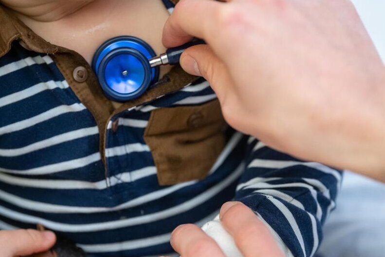 Newsblog Corona: Ungewöhnliche Häufung von Atemwegsinfekten bei Kindern - Ein Arzt untersucht ein Kind mit einem Stethoskop.