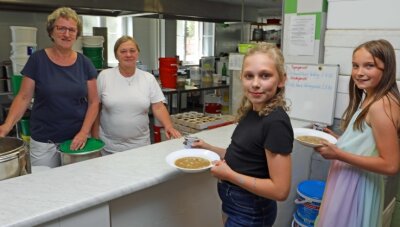 Nicht nur in Crimmitschau: Preise für Schulessen schnellen in die Höhe - Die Neukirchener Viertklässlerinnen Leena (l.) und Jule haben ihr Mittagessen bei Ramona Huth (l.) und Chefin Evelin Hellwig abgeholt. 