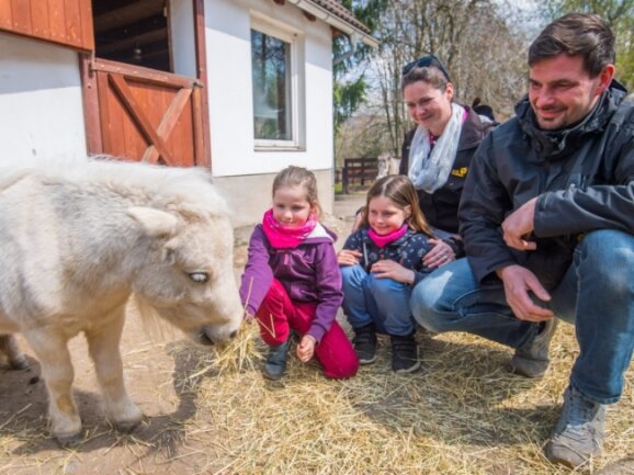 Der Zoo der Minis darf trotz Notbremse weiter öffnen. Darüber freuen sich Alissa Egermann, Maryana Egermann, Mutter Janka Egermann und Vater Marcus Weißflog (v. l.) - hier mit ihrem Patentier Trude. 