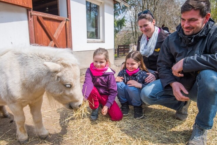 Der Zoo der Minis darf trotz Notbremse weiter öffnen. Darüber freuen sich Alissa Egermann, Maryana Egermann, Mutter Janka Egermann und Vater Marcus Weißflog (v. l.) - hier mit ihrem Patentier Trude. 